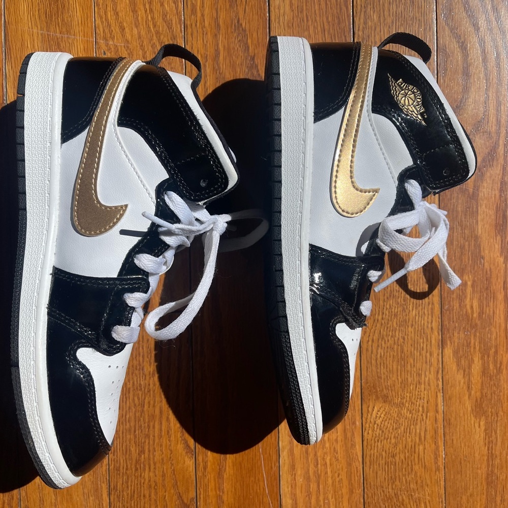Boys Nike Jordans in size 3Y in white with gold swoosh and black accents.